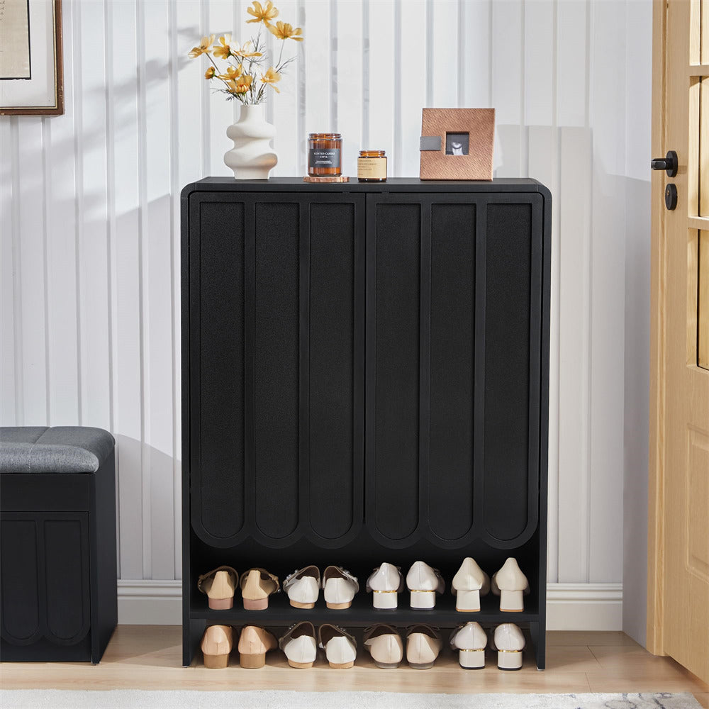 Black 5-tier wooden shoe cabinet with shoes on a wooden floor against a white wall.