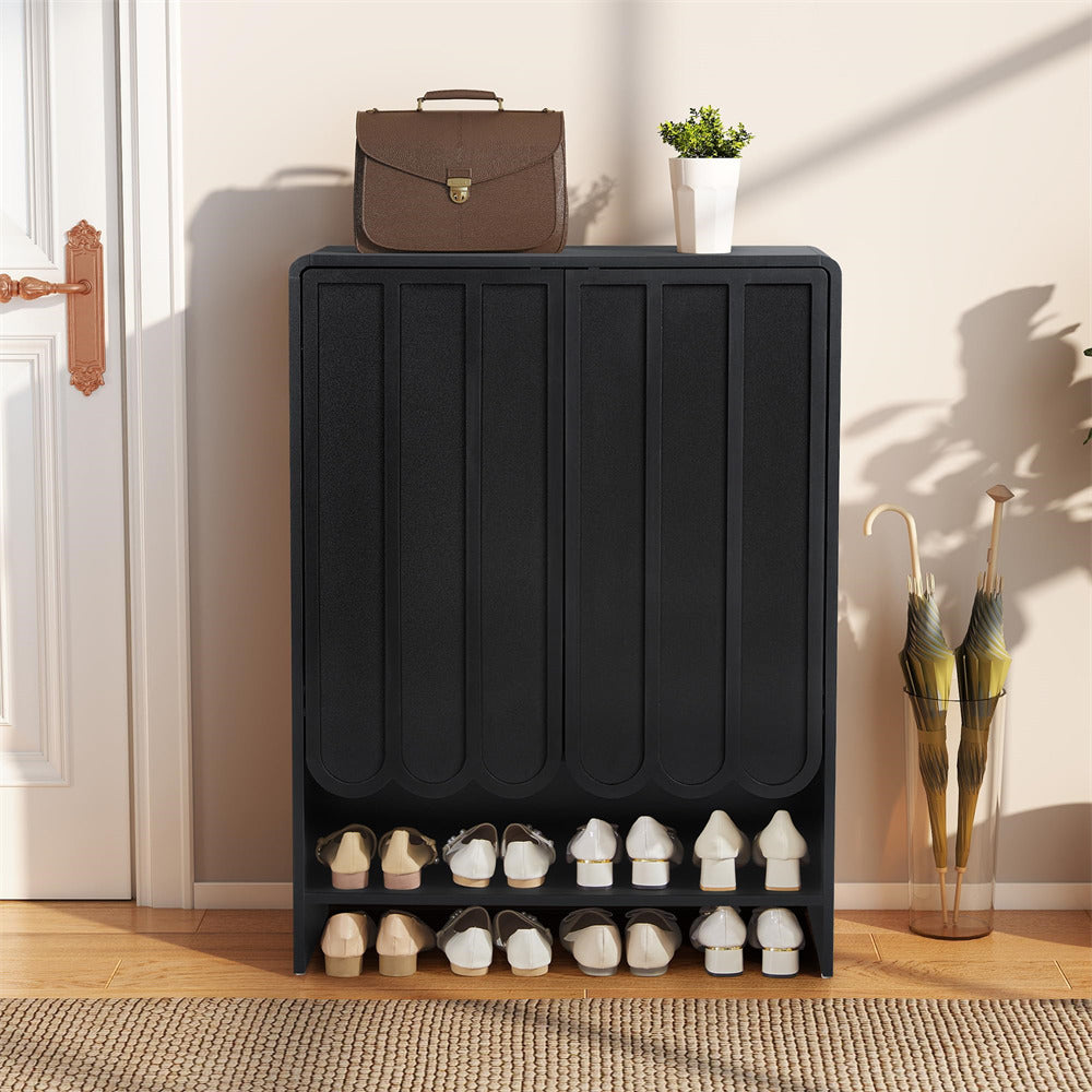 Black 5-tier wooden shoe cabinet with shoes on a wooden floor next to a door.