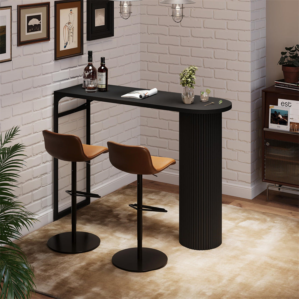 Black bar table with two brown stools against a white brick wall.