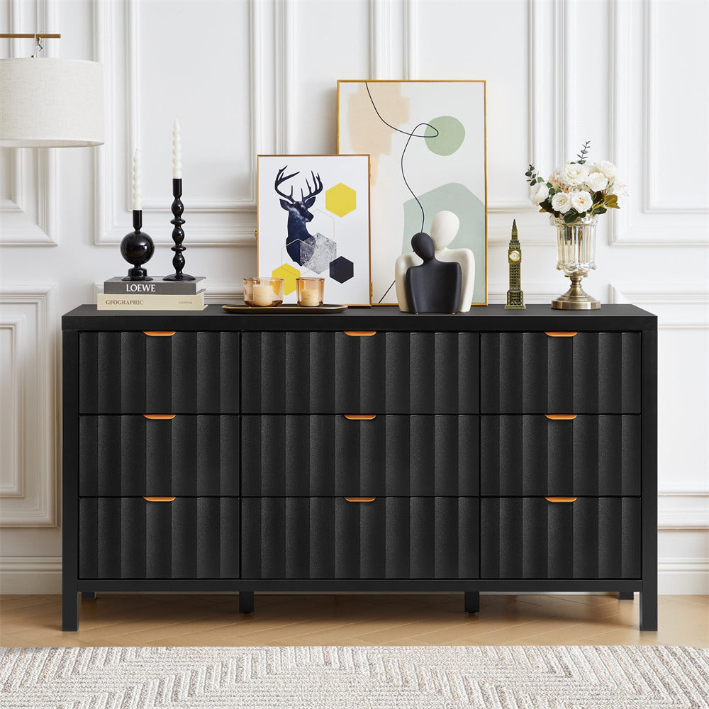Black dresser with decorative items in a room with white paneled walls and a rug.
