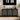 Black sideboard with decorative items and a digital clock above in a living room setting.