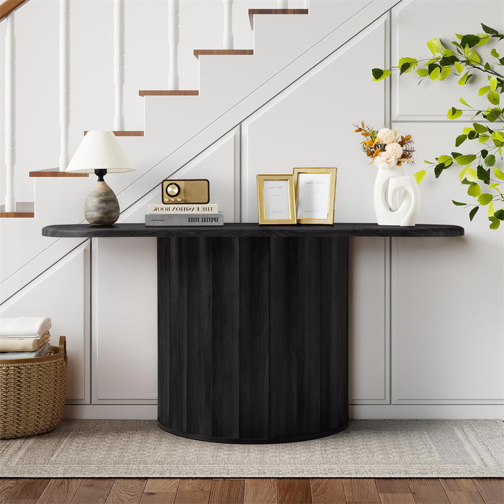 Black console table with decorative items against a white wall with stairs