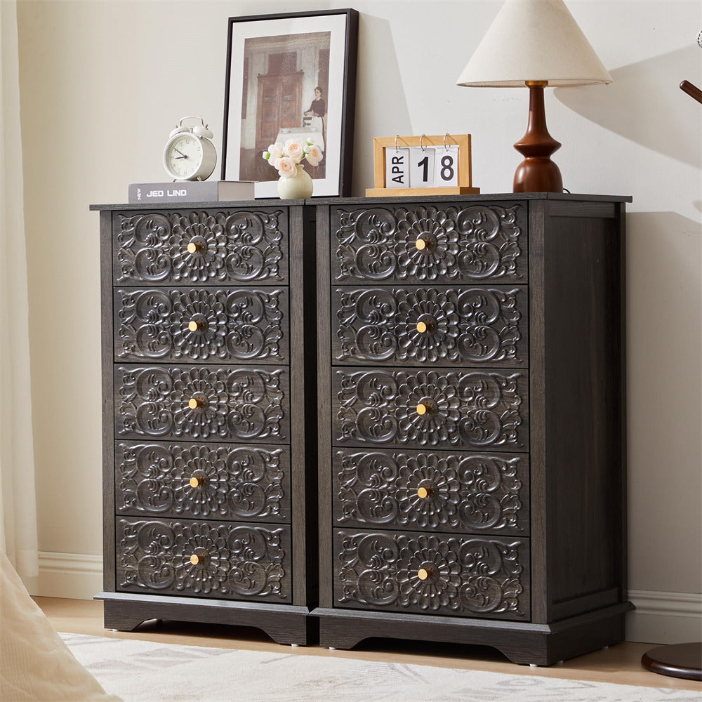 Decorative black chest of drawers with intricate carvings in a room setting.