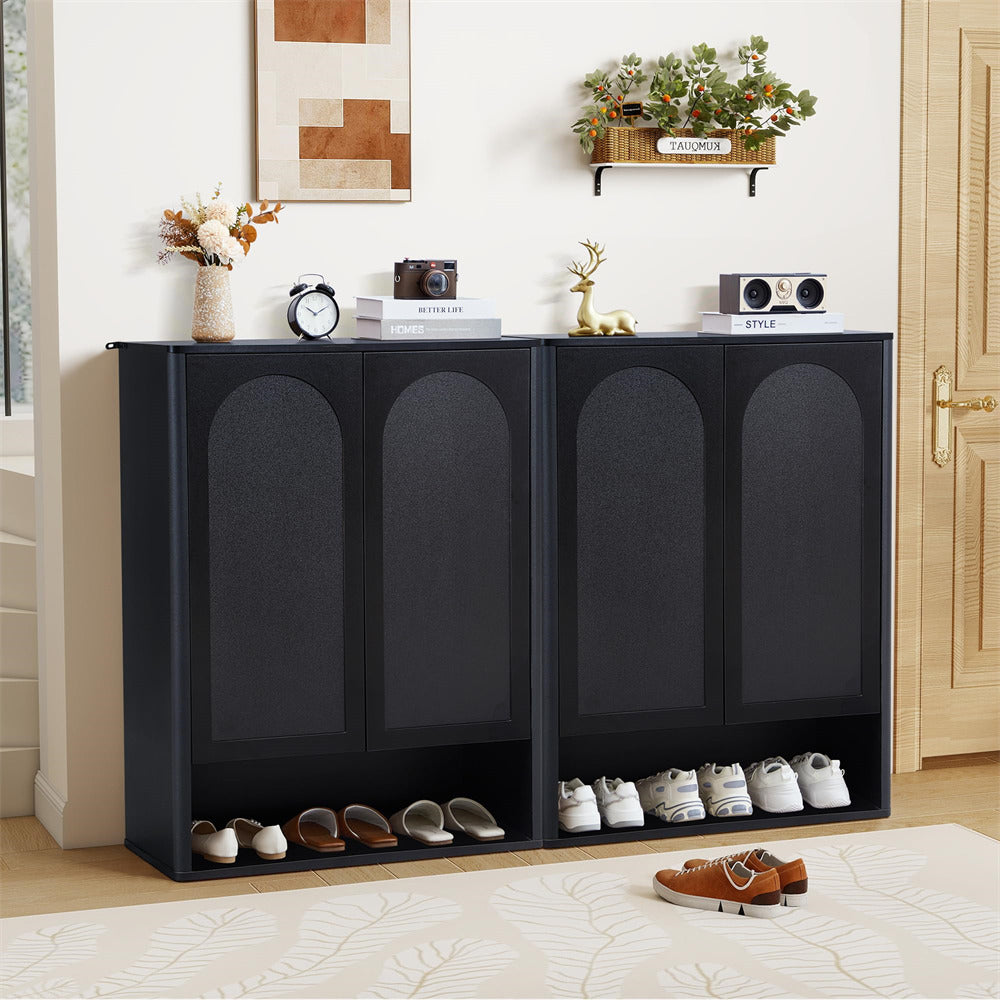 Black shoe cabinet with shoes inside, placed in a room with decor elements.