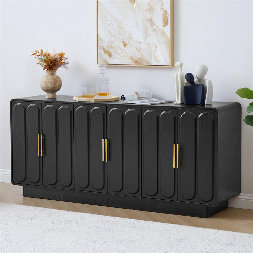 Black sideboard with gold handles in a room with decor elements.