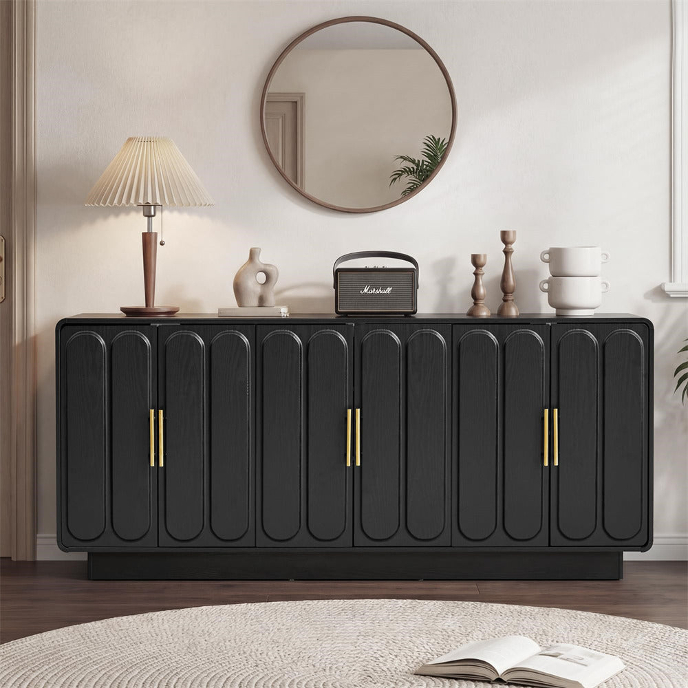 Black sideboard with gold handles in a room setting with decor items.