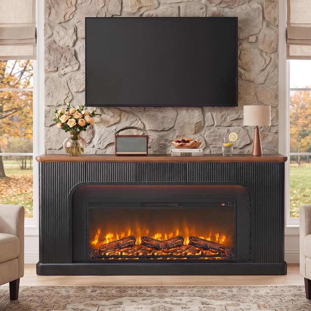 A modern electric fireplace with a black ribbed mantel and glowing faux logs, styled in a living room setting against a stone wall with a mounted TV and home decor.
