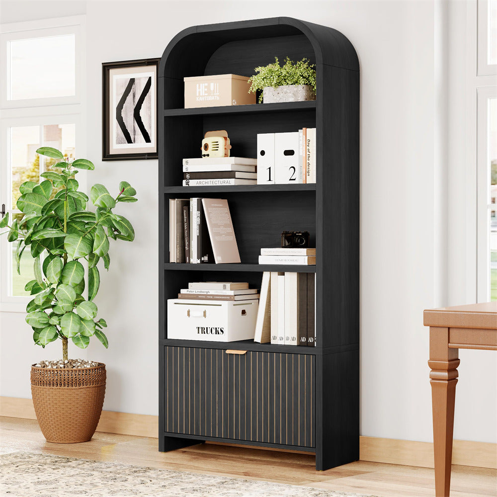 Black bookshelf with decorative items in a room with a plant and table.
