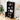 Black bookshelf with decorative items in a room with a plant and wall art.