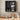 Black wall-mounted cabinet with kitchen items on a tiled wall background