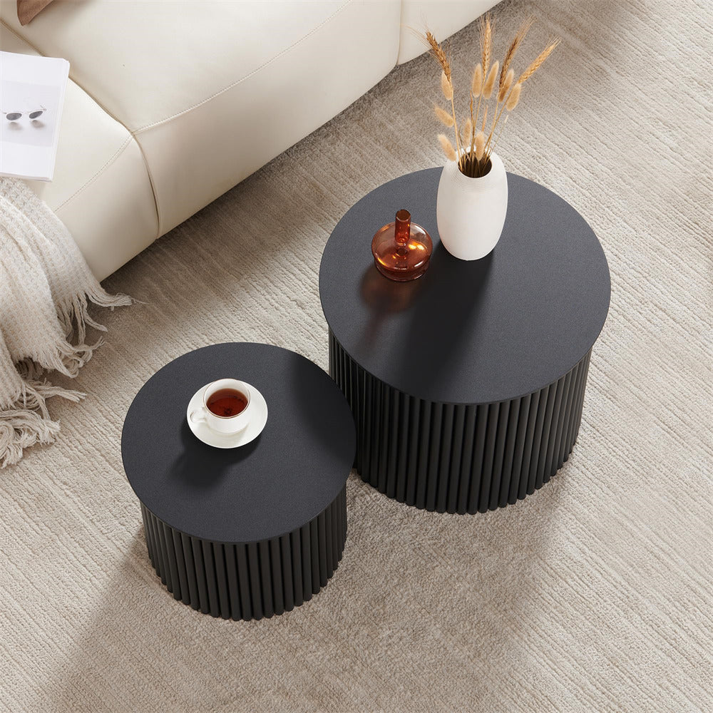 Two black side tables with decorative items on a beige carpeted floor.