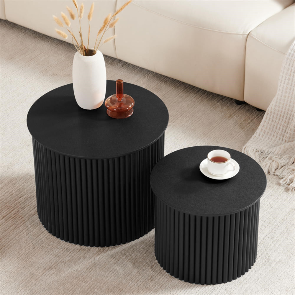 Two black side tables with decorative items on a beige carpeted floor.
