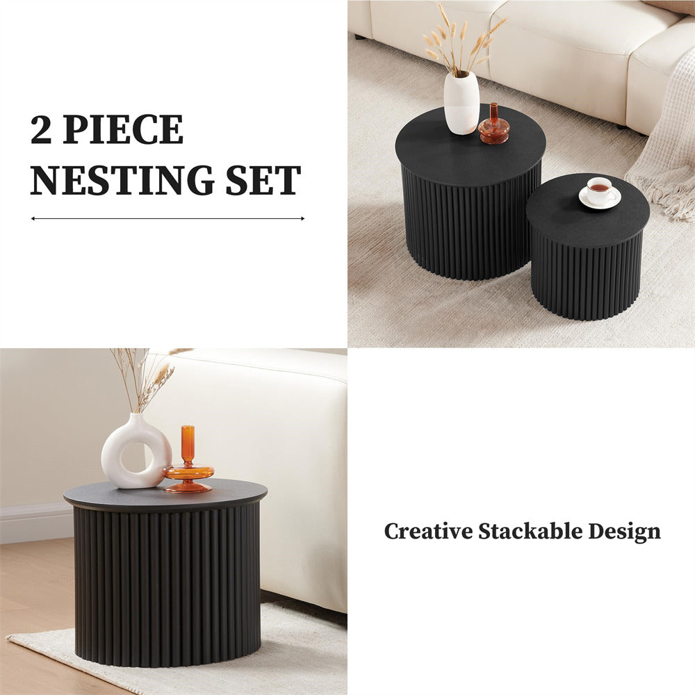 Two black nesting tables with decorative items on a neutral background