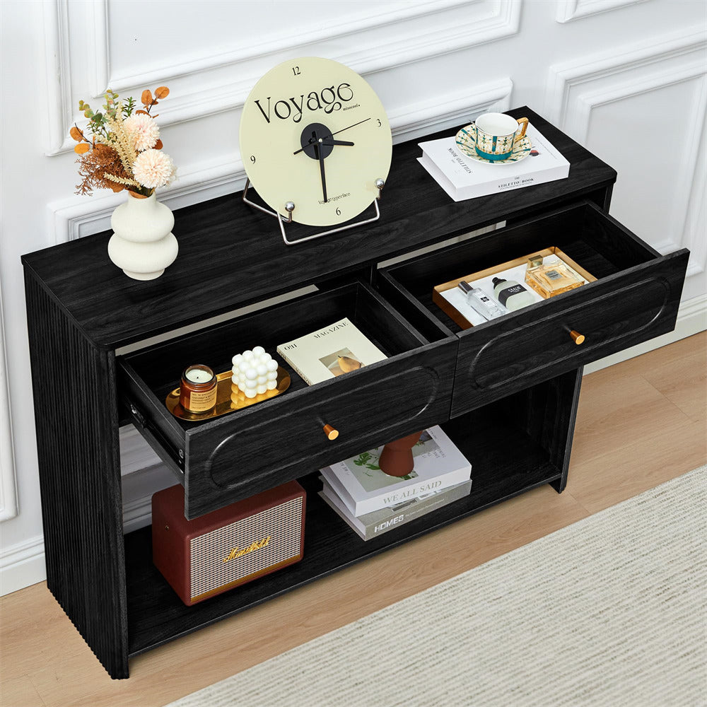 Black console table with open drawers, decorative items, and a clock on a white wall background.
