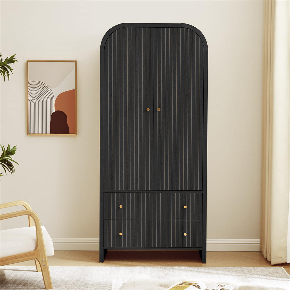 Black wardrobe with gold handles in a room with a chair and abstract art on the wall.