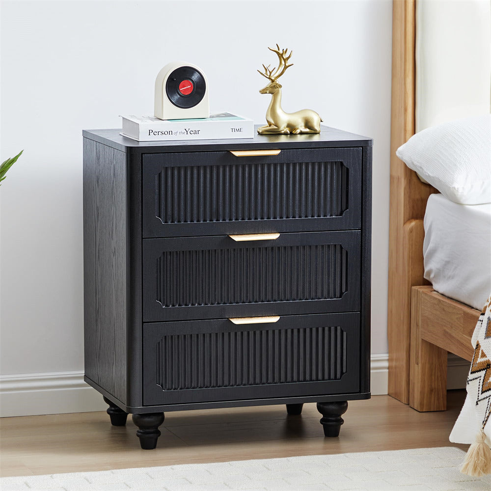 Black three-drawer nightstand with decorative items in a bedroom setting