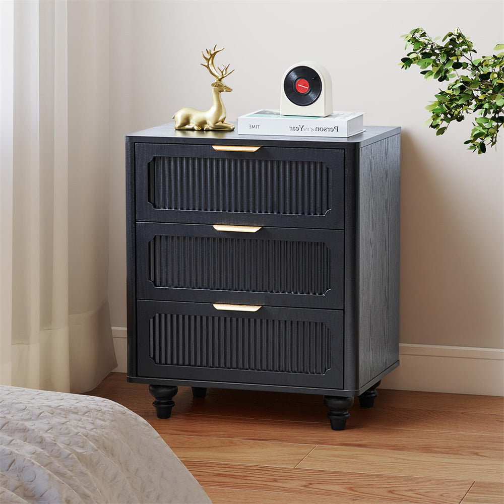 Black nightstand with decorative items on a wooden floor.