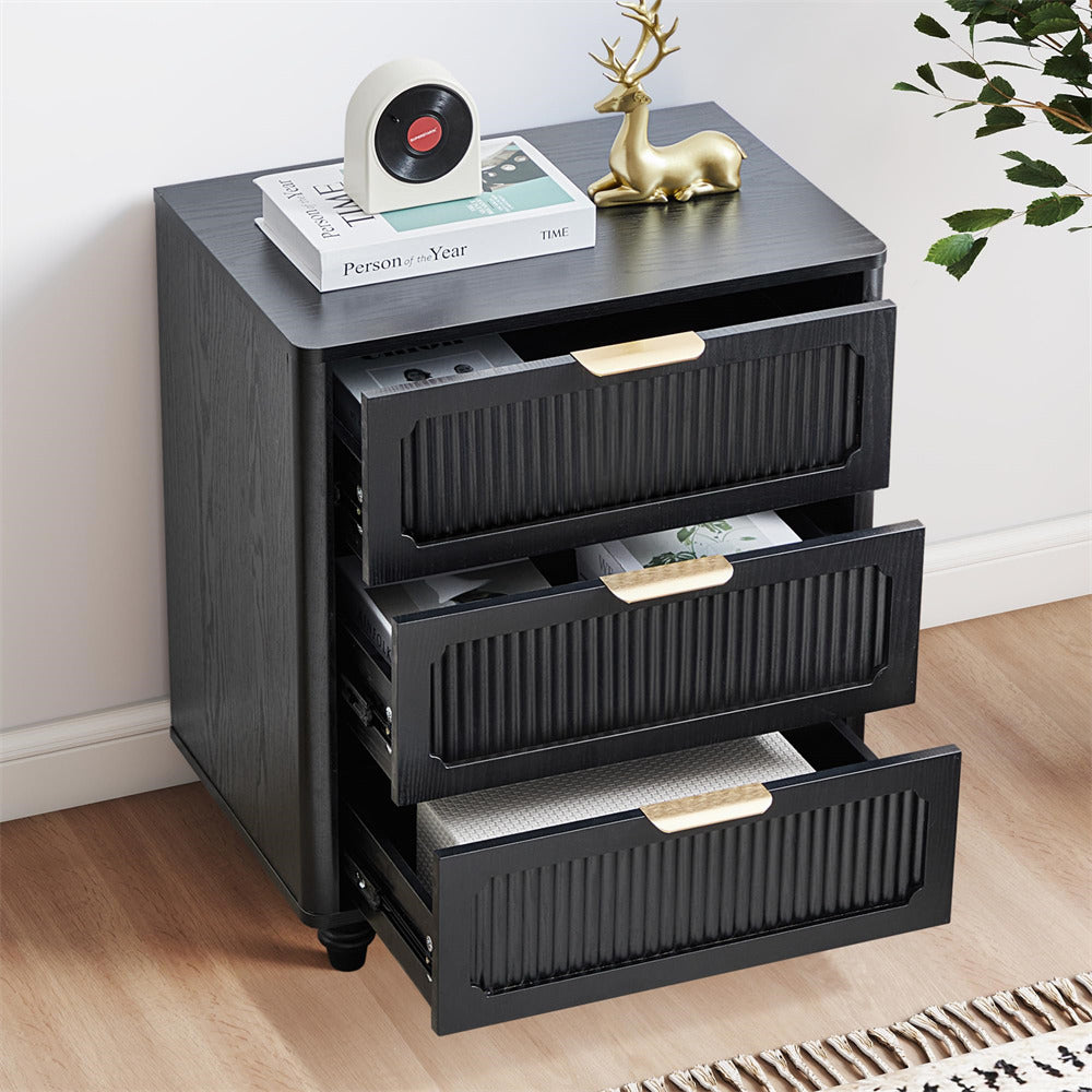 Black three-drawer nightstand with decorative items on a wooden floor.