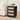 Black nightstand with beige drawers next to a white sofa in a living room.
