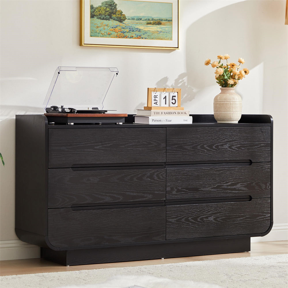 Black 6-drawer dresser with vinyl record player, calendar, and vase in a room setting.