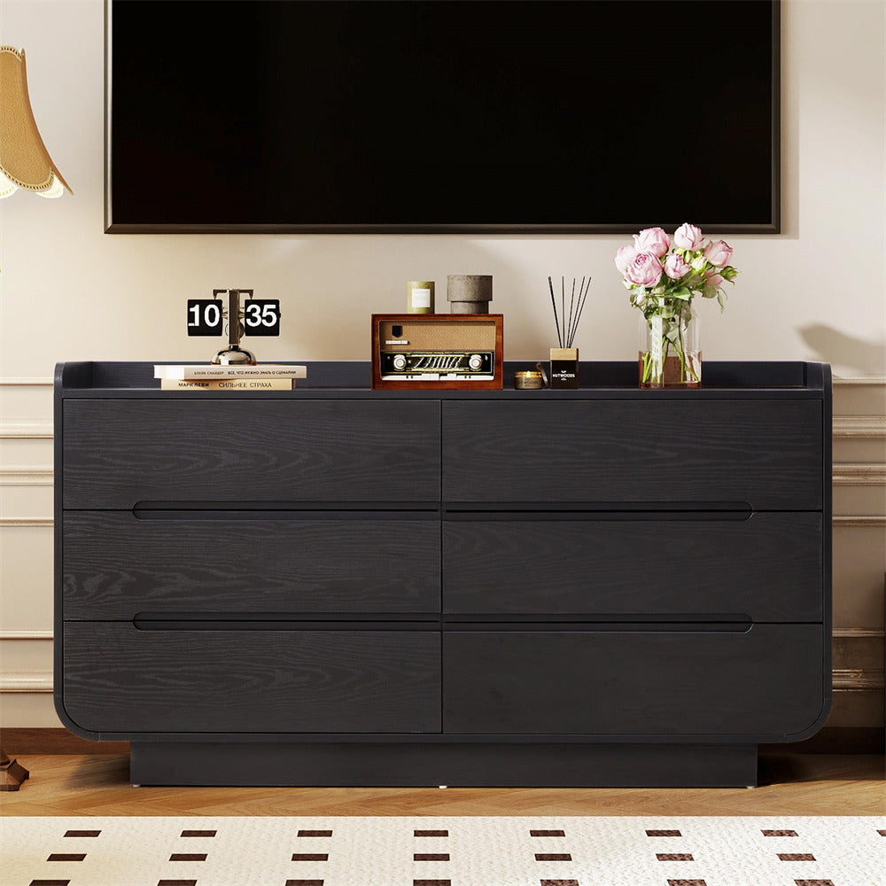 Black 6-drawer dresser with decorative items in a room setting