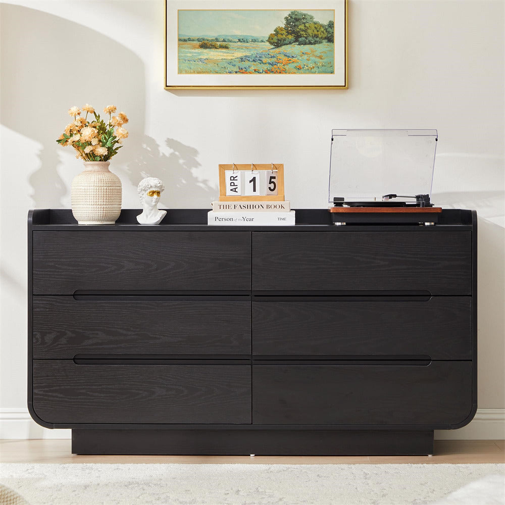 Black 6-drawer dresser with decorative items in a room setting