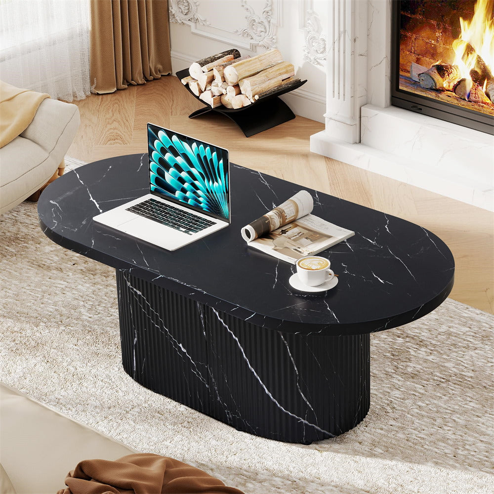 Black marble coffee table with a laptop, newspaper, and cup in a living room setting.