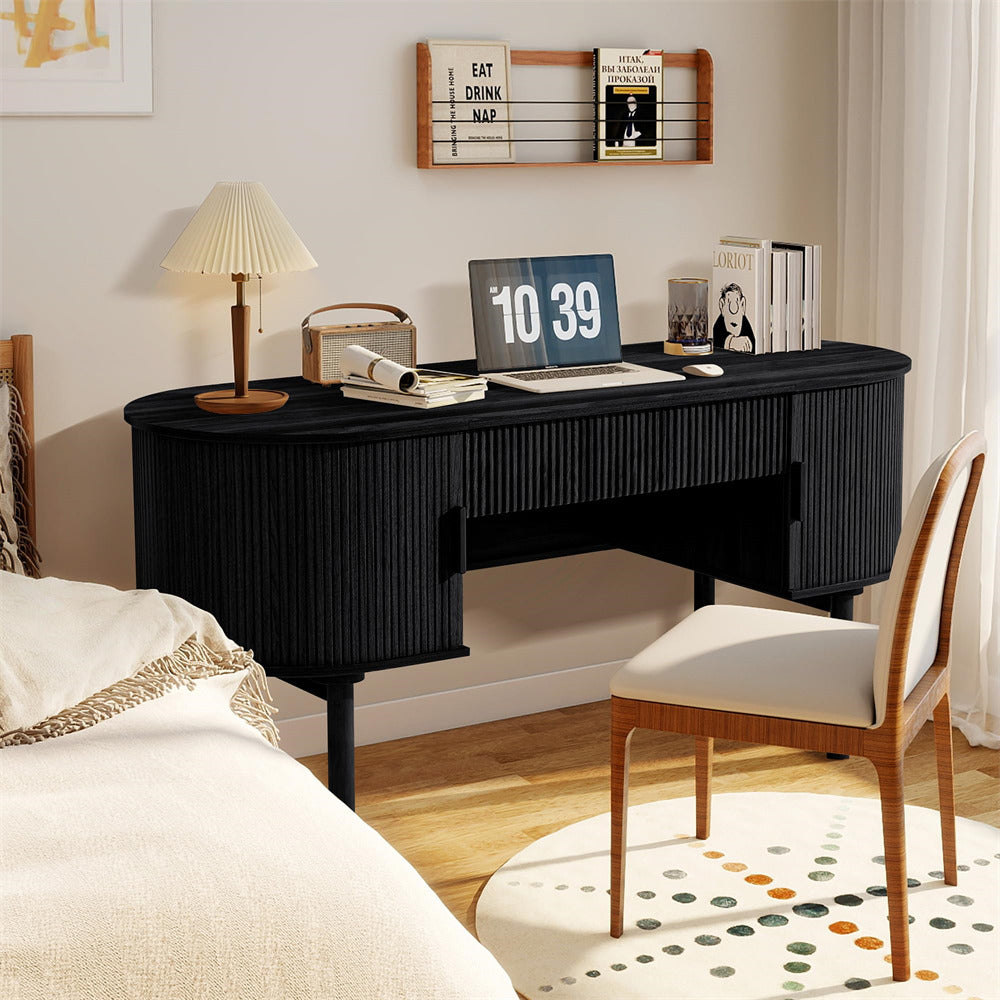 Black desk with laptop, books, and decor in a bedroom setting