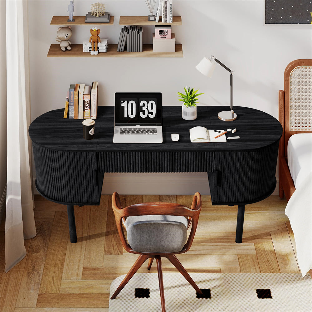 Black desk with laptop, books, and decor in a home office setting