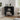 Black corner cabinet with decorative items in a room with a window and plant.