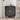 Black cabinet with gold circular design in a room setting with a stool and decor items.