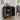 Black cabinet with open doors displaying items in a room with a dining table and chairs.