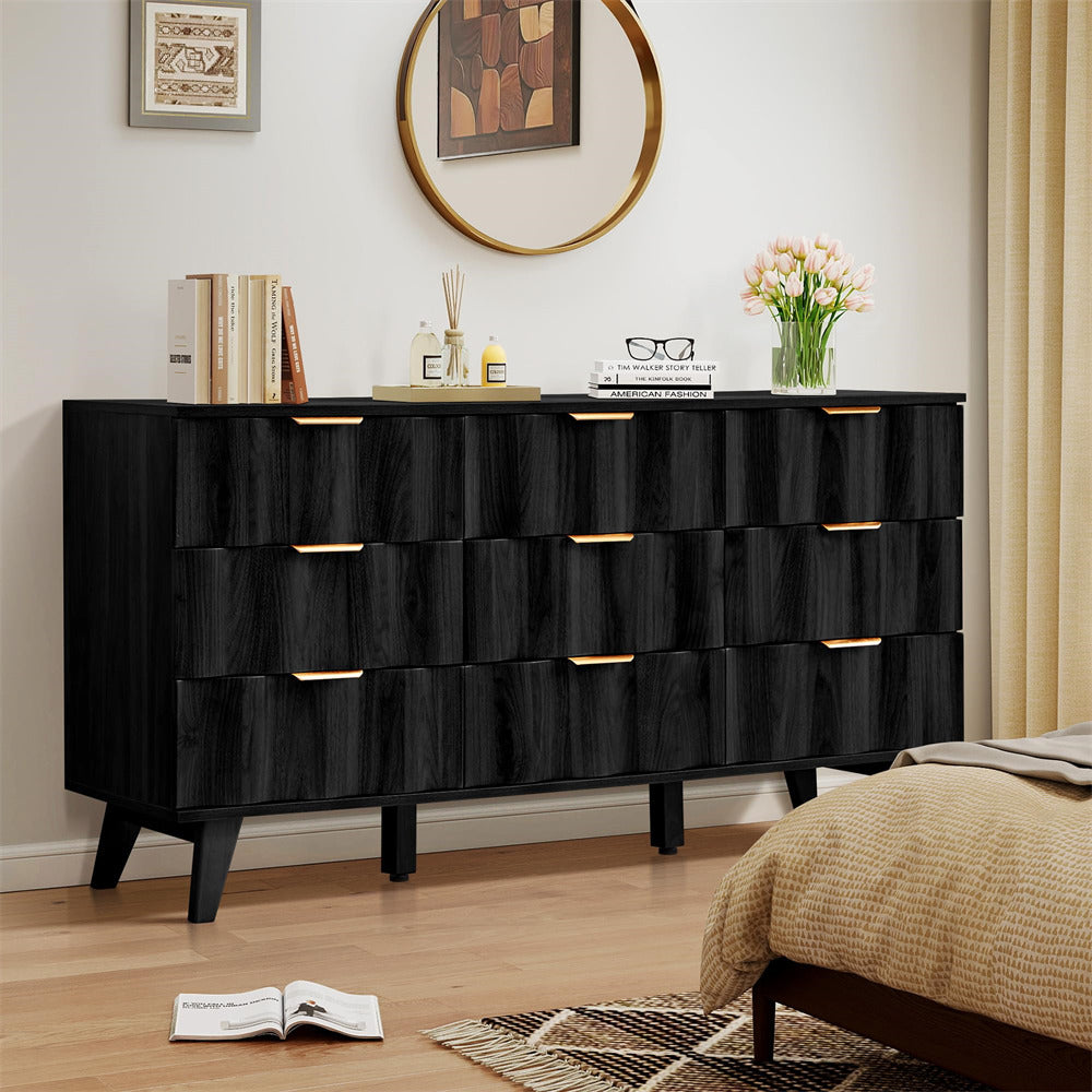 Black dresser with gold handles in a bedroom setting