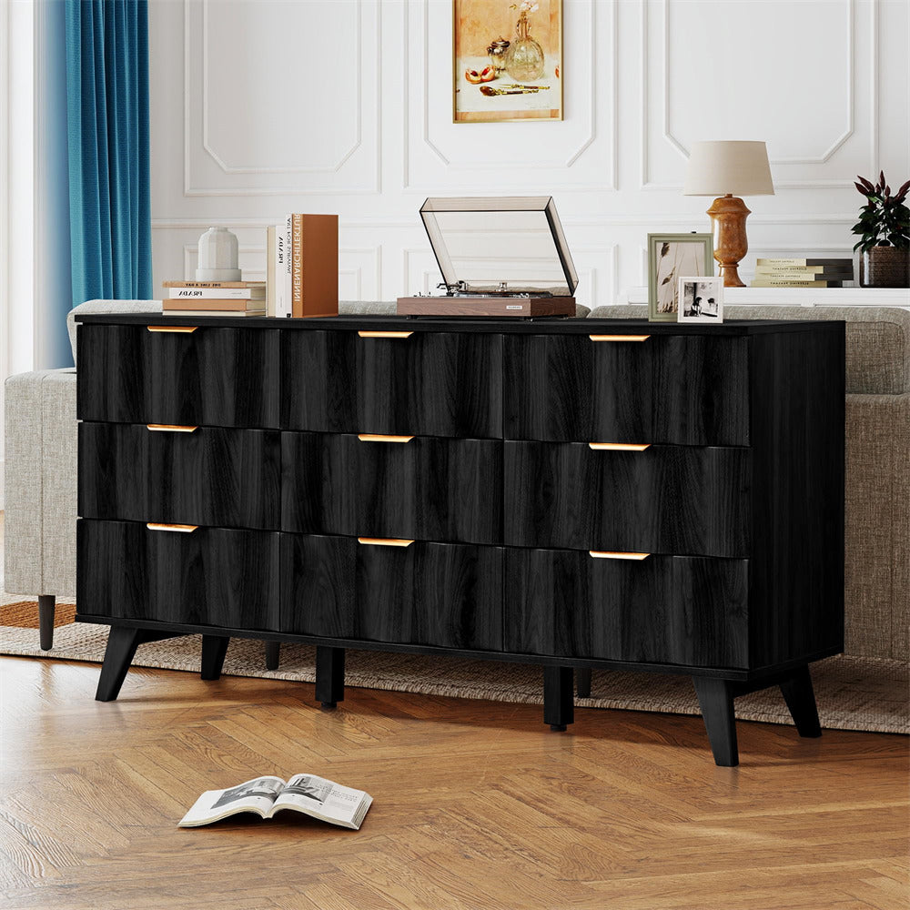 Black dresser with gold accents in a room with a couch and books.
