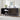 Black sideboard with decorative items against a white brick wall