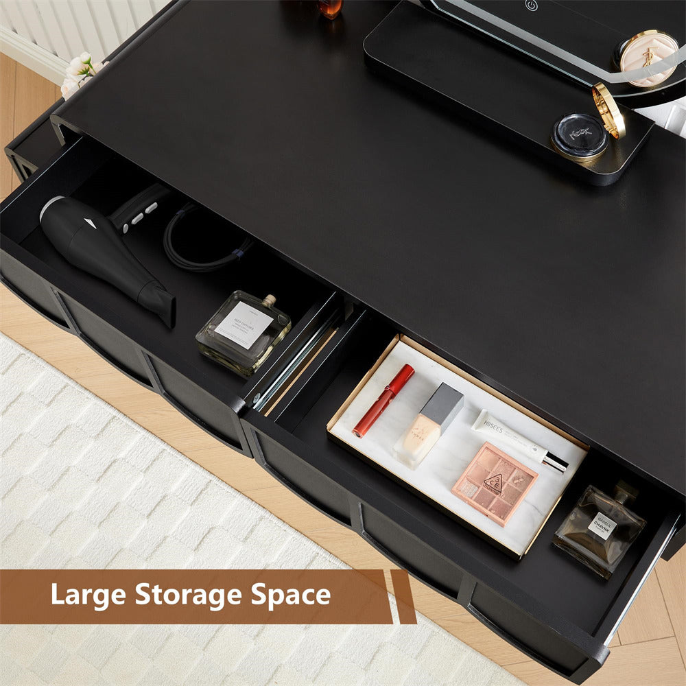 Black desk with open drawer containing office supplies on a light wooden floor.
