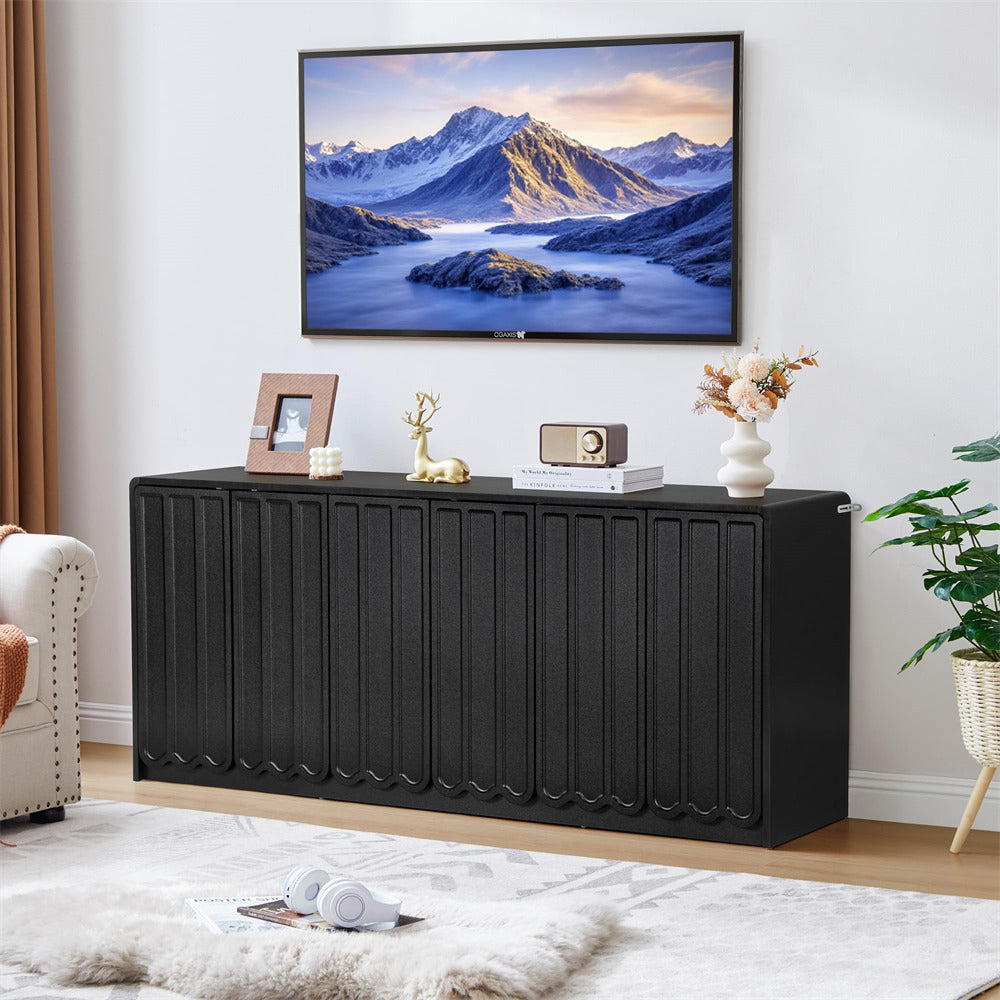 Black console table with decorative items against a wall-mounted TV displaying a mountain scene.