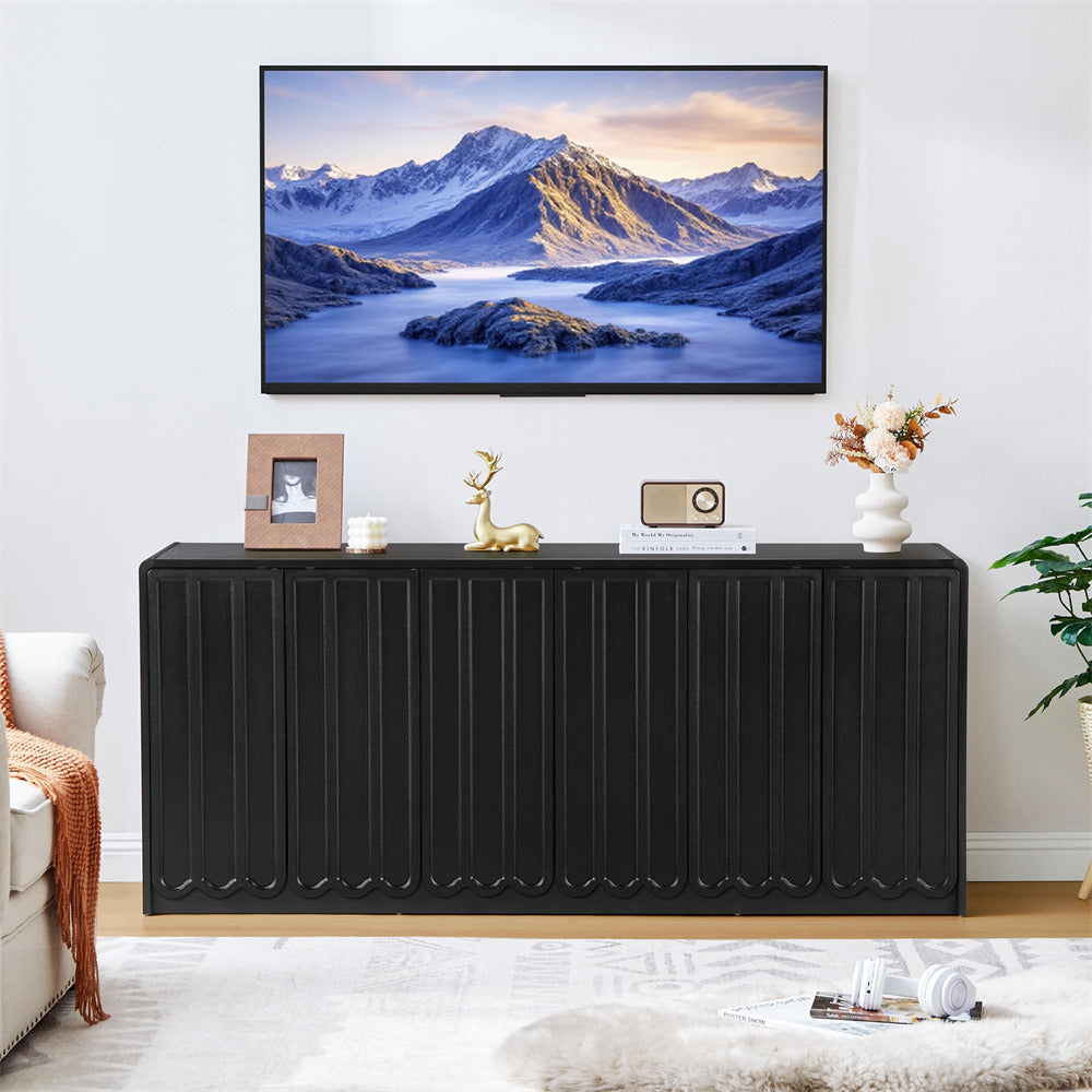 Modern living room with a black console table, TV displaying a mountain scene, and decorative items.