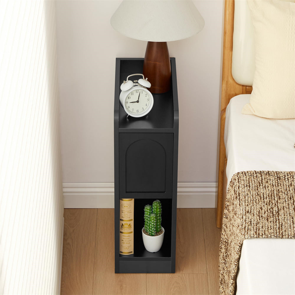 Black narrow shelf with decorative items next to a bed