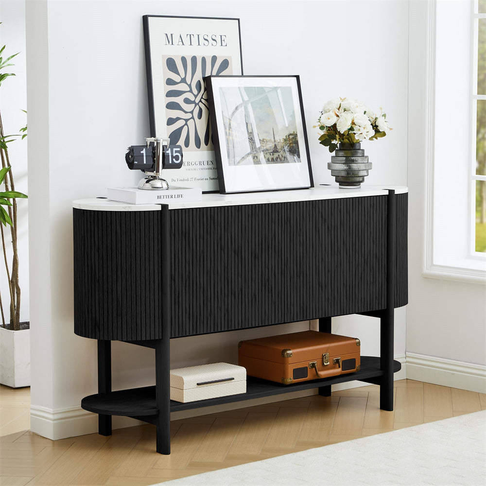 Black console table with decorative items in a room with a window and plant.