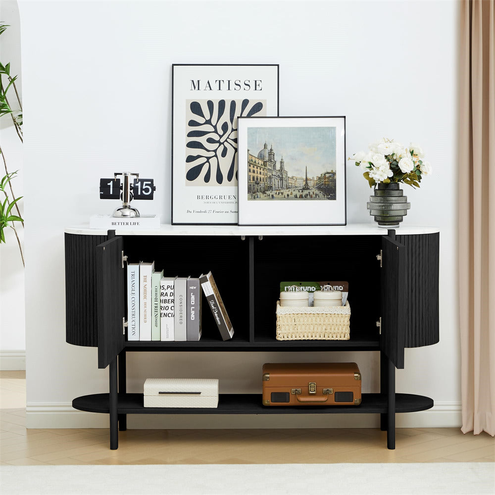 Black storage cabinet with books, a suitcase, and decorative items in a room with framed art on the wall.