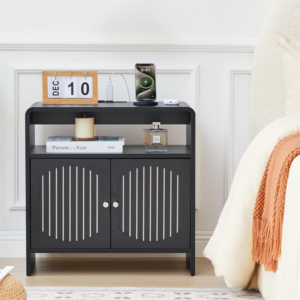 Black nightstand with decorative items against a white wall