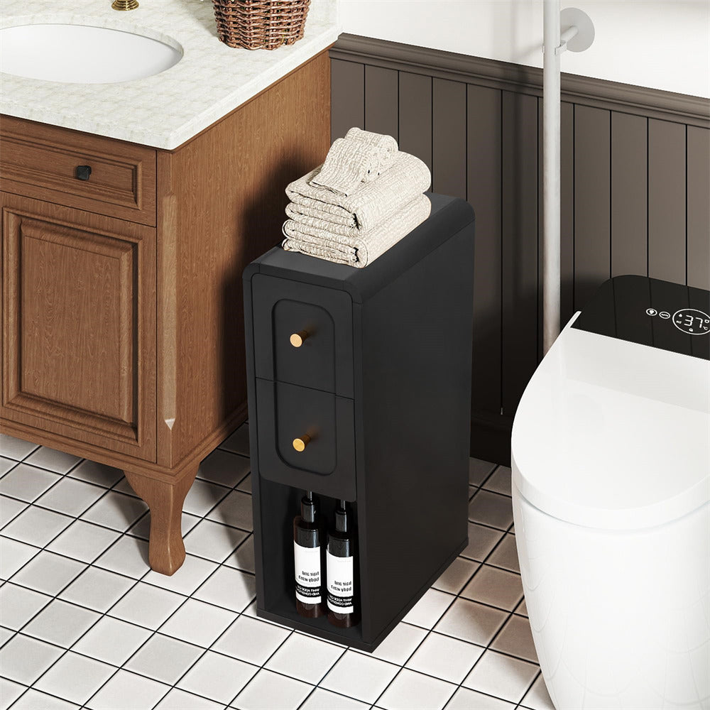 A black bathroom vanity organizer with two drawers and a top shelf holding folded towels, placed beside a wooden bathroom vanity and toilet.
