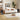 A modern white fabric daybed with light wood legs, styled in a warm, contemporary living room setting with decorative pillows, a plush toy, side tables, framed wall art, and a large potted plant.