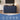 A navy blue ribbed TV stand cabinet shown in a styled living room setting with a TV, lamp, plants, and side table. A blue banner at the bottom reads 'Multi-scenes' with icons for TV stand, sideboard cabinet, kitchen cabinet, credenza, and coffee bar cabinet.