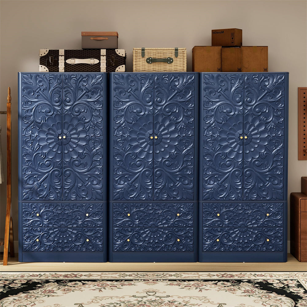 A large three-door navy blue storage cabinet with ornate embossed floral patterns and small gold knobs, shown in a styled room setting with vintage boxes on top and a patterned rug below.