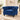 A royal blue velvet Chesterfield armchair with silver nailhead trim, set in a bright, elegant living room with a beige rug and warm sunlight.