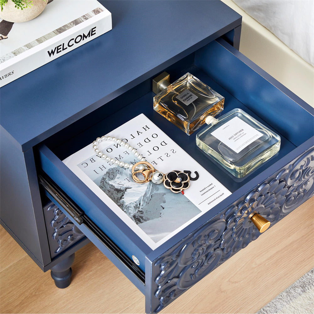 Blue nightstand with open drawer containing a magazine, necklace, and two perfume bottles.