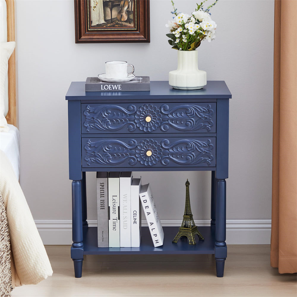 Navy blue nightstand with decorative drawer and shelf, featuring books and a small statue.