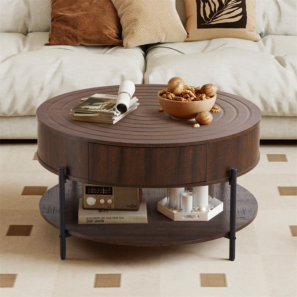 Round wooden coffee table with a bowl of nuts and magazines on top, in a living room setting.